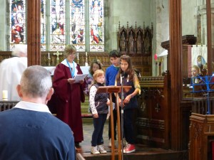 Children from Rocky's Plaice assist with prayers.