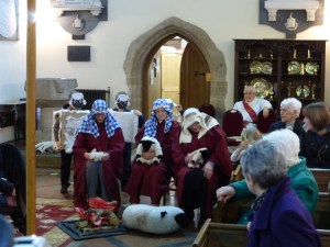 Three shepherds are sat around a campfire with their sheep discussing the big star in the sky